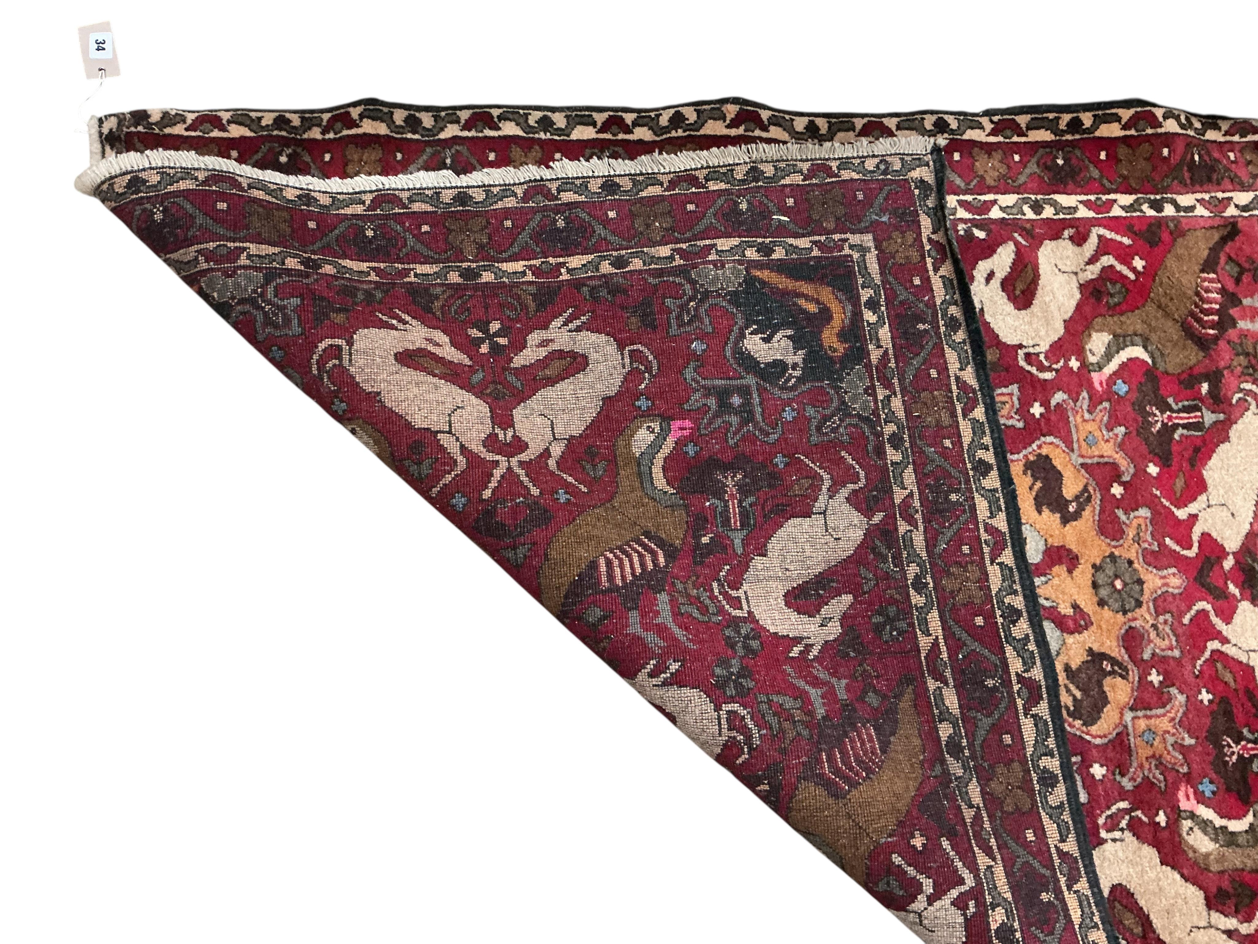 A North West Persian red ground pictorial rug, 180 x 104cm